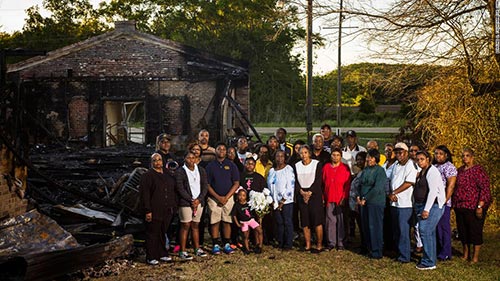 Members of the Greater Union Baptist Church standing in front of the ruins of their church
